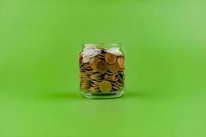 salvando moedas dentro uma vidro jarra finança conceito, renda, lucro, salário foto