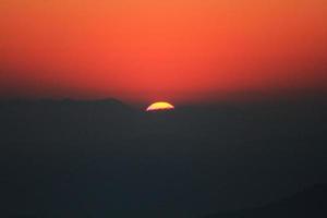 pôr do sol dentro céu e nuvem, lindo colorida crepúsculo Tempo com silhueta do montanha. foto