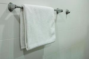 branco banho toalha suspensão em a banheiro foto