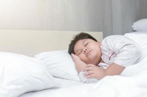 peidar Garoto dormir em cama dentro quarto foto