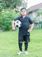 em pé obeso gordo Garoto futebol jogador com futebol foto