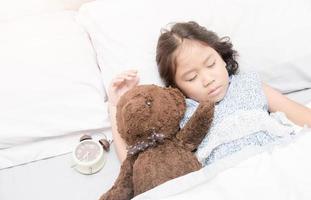 fofa pequeno ásia menina dormir e abraço Urso de pelúcia Urso foto