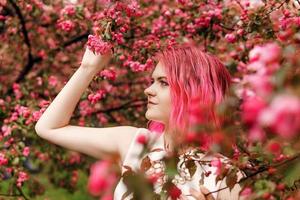 jovem menina com Rosa cabelo dentro maçã Pomar. foto