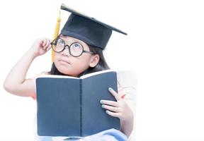 feliz estudante de escola asiática graduado pensando com boné de formatura foto