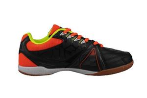 Preto tênis com laranja atacadores e listras. foto