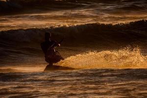 kitesurfer às pôr do sol foto