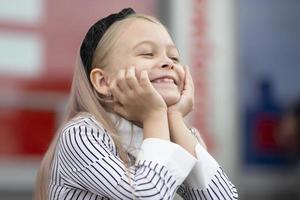 engraçado pequeno Loiras menina sorrisos belas. uma rado criança. foto