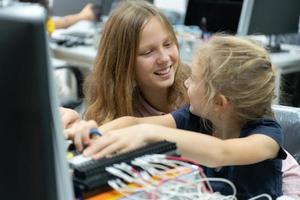 crianças usando a mão robô tecnologia e tendo Diversão Aprendendo a eletrônico o circuito borda do mão robô tecnologia, que é 1 do a haste cursos. foto