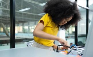 jovens utilizando a mão robô tecnologia estão tendo Diversão Aprendendo a eletrônico o circuito borda do mão robô tecnologia, que é 1 do a haste cursos. foto