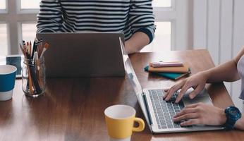 duas pessoas trabalhando em uma mesa foto