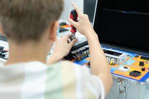 jovens utilizando a mão robô tecnologia estão tendo Diversão Aprendendo a eletrônico o circuito borda e mão robô controlador do robô tecnologia, que é 1 do a haste cursos. foto