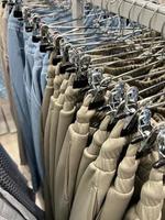 roupas em uma cabide dentro uma loja. sortimento dentro a fazer compras janela. compras verão fêmea. foto