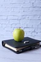 caderno e maçã em um fundo azul foto