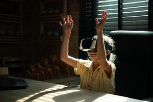 retrato do pequeno menina dentro escritório quarto do casa com gestos este estão expresso quando jogando virtual realidade jogos foto