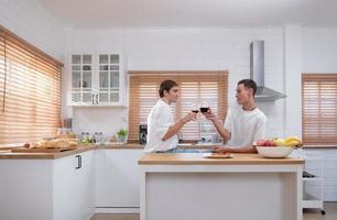 lgbt jovem casal comemoro a dia do amor entre cada de outros com bem vinho dentro a cozinha do a casa foto