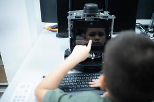 jovens utilizando a mão robô tecnologia estão tendo Diversão Aprendendo a eletrônico o circuito borda e mão robô controlador do robô tecnologia, que é 1 do a haste cursos. foto