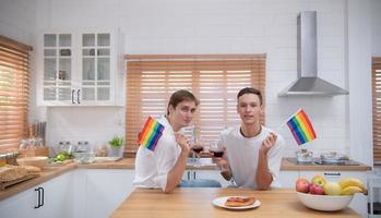 lgbt jovem casal comemoro a dia do amor entre cada de outros com bem vinho dentro a cozinha do a casa foto