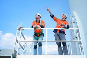 agrimensor e engenheiro examinar a eficiência do gigantesco vento turbinas este transformar vento energia para dentro elétrico energia este é então usava dentro diariamente vida. foto