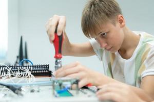 jovens utilizando a mão robô tecnologia estão tendo Diversão Aprendendo a eletrônico o circuito borda e mão robô controlador do robô tecnologia, que é 1 do a haste cursos. foto