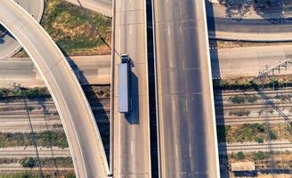 aéreo Visão do carga caminhão em rodovia estrada com azul recipiente, transporte conceito.,importar,exportar logístico industrial transportando terra transporte em a asfalto via Expressa foto