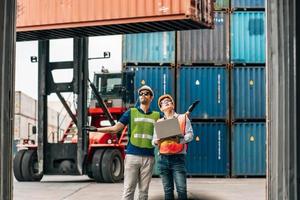 equipe engenheiro e trabalhador vestem segurança uniforme Verifica ao controle Carregando frete carga recipiente usar computador computador portátil às comercial doca armazém, transporte importar, exportar logístico industrial serviço foto