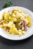 fresco batata salada, pepino, salsicha, maionese pronto para comer refeição Comida lanche em a mesa cópia de espaço Comida fundo rústico topo Visão foto