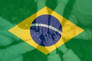 mãos do crianças em fundo do Brasil bandeira. brasileiro patriotismo e unidade conceito. foto