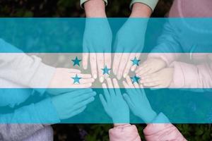 mãos do crianças em fundo do Honduras bandeira. hondurano patriotismo e unidade conceito. foto