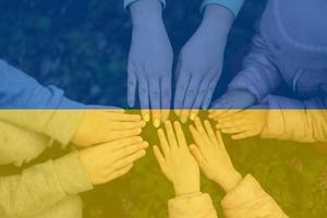mãos do crianças em fundo do Ucrânia bandeira. ucraniano patriotismo e unidade conceito. foto