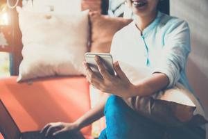 mulher feliz usando smartphone e notebook para fazer compras online.technology e conceito de comércio eletrônico. foto