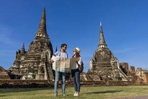 casal de turistas vem visitar o templo wat phra si sanphet, ayutthaya tailândia usando mapas para viagens, férias, férias, lua de mel e conceito de turismo foto