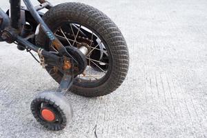 quatro roda bicicleta. ajudar rodas para Socorro uma criança aprender para passeio uma bicicleta foto