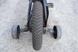 quatro roda bicicleta. ajudar rodas para Socorro uma criança aprender para passeio uma bicicleta foto