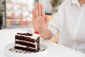 fêmea saudável confundir chocolate bolo. mulher dentro restaurante atinge peso perda objetivo para saudável vida, louco sobre magreza, fino cintura, nutricionista. dieta, corpo forma. foto