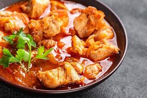 frango carne tomate molho, vegetal refeição Comida lanche em a mesa cópia de espaço Comida fundo rústico topo Visão foto