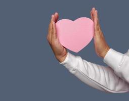 masculino mão segurando Rosa coração forma isolado em avião fundo. foto
