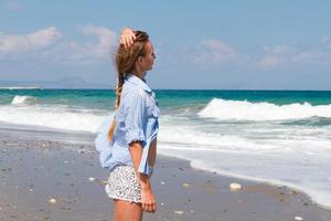 mulher desfrutando a mar brisa em a de praia em uma tropical ilha foto