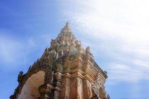 Veja acima Visão do tradicional e antigo tailandês lanna arte Entrada portão do debaixo brilhante azul céu com Sol e lente flare fundo . foto