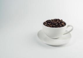 assado arábica café feijões, pronto para faço café este pessoas gostar para bebida. colocada dentro uma branco café copo em a fundo. parece lindo e apetitoso. bebida. foto