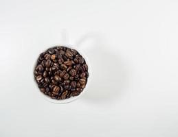 assado arábica café feijões, pronto para faço café este pessoas gostar para bebida. colocada dentro uma branco café copo em a fundo. parece lindo e apetitoso. bebida. foto