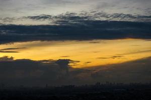 pôr do sol dentro a subúrbios do Jacarta, Onde a céu começa para Veja amarelo e você pode Vejo a silhuetas do de várias alta edifícios foto