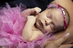 recém-nascido inteligente menina dorme dentro dela braços. foto