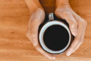 xícara de café preto fresco na mesa de madeira foto