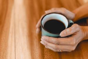 xícara de café preto fresco na mesa de madeira foto