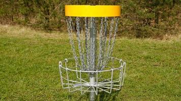 disco golfe cesta. frisbee golfe é esporte e hobbie dentro ao ar livre parque. metal cesta com correntes para disco jogos cercado de vibrante verde árvores foto