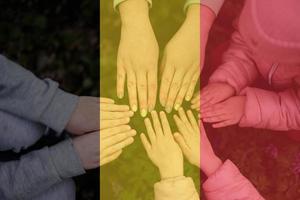 mãos do crianças em fundo do Bélgica bandeira. Belga patriotismo e unidade conceito. foto