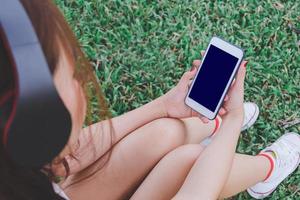 senhora ouvindo música a partir de inteligente telefone com fones de ouvido foto