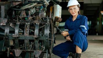 fêmea mecânico engenheiro trabalhando dentro maquinaria dentro indústria. trabalhadores vestindo segurança óculos. trabalhando. industrial conceito. foto