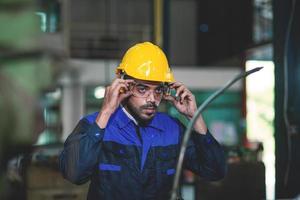 especialista engenheiros ou trabalhadores segurando uma branco chapéu feliz para trabalhos dentro a industrial fábrica. foto