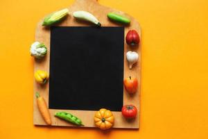 legumes e frutas na tábua em fundo amarelo. conceito de culinária saudável foto